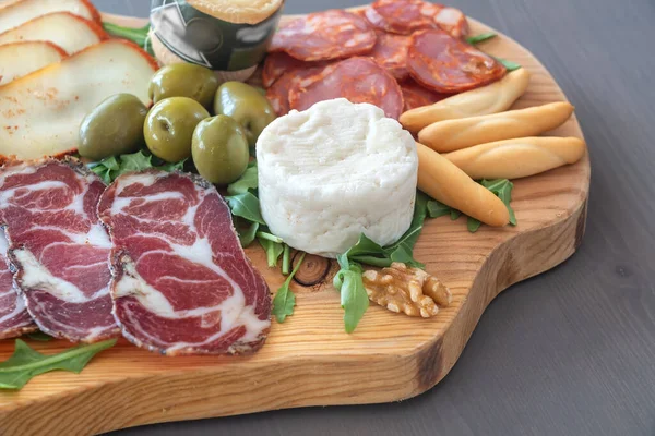 Very colorful tapas board of charcuterie with cheese and smoked meats. Decorated with arugula and walnuts. Wine snacks. — Stock Photo, Image