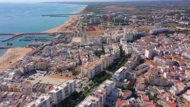 İnsansız hava aracı görüntüleri, Atlantik Okyanusu kıyısında turist kasabası Quareira 'yı çekiyor, turistlerle dolu plajlar. Portekiz, Algarve. — Stok video