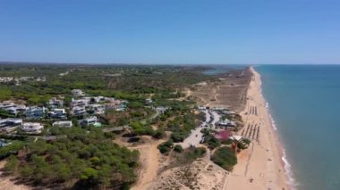 Vale de Lobo, Algarve, Portekiz, Avrupa 'daki Quinta do Lago tatil köylerinin hava manzarası. Yeşil manzaralı, arka planda dağlar olan lüks kulübelerin çatıları. Golf alanları.