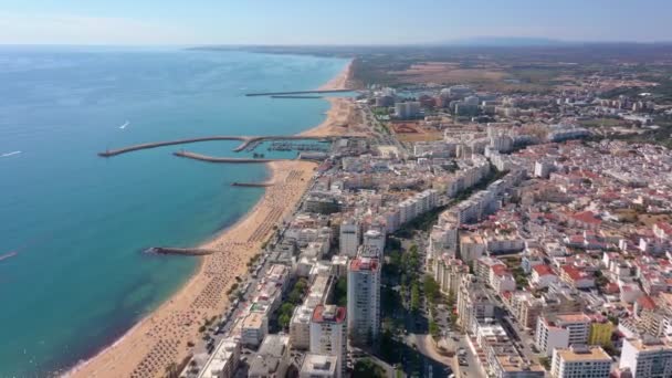 Vista aérea de arriba hacia abajo de los techos de la carretera y las calles entre pequeñas casas de colores en el centro de Quarteira, Portugal — Vídeo de stock