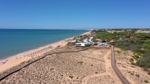 Drohnenaufnahmen aus der Luft, die Stranddünen mit hölzernen Wegen zum Meer filmen. Portugal, Algarve. — Stockvideo