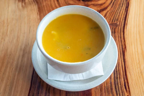 Zucca naturale, zuppa di zucca al burro in una ciotola bianca. Su uno sfondo di legno. Chiudete. Vista dall'alto. — Foto Stock