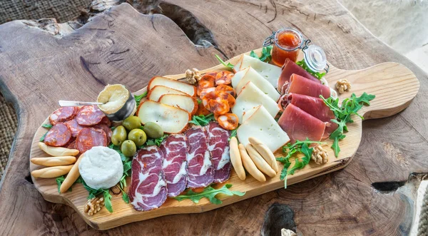 Very colorful tapas board of charcuterie with cheese and smoked meats. Decorated with arugula and walnuts. Wine snacks. — Stock Photo, Image