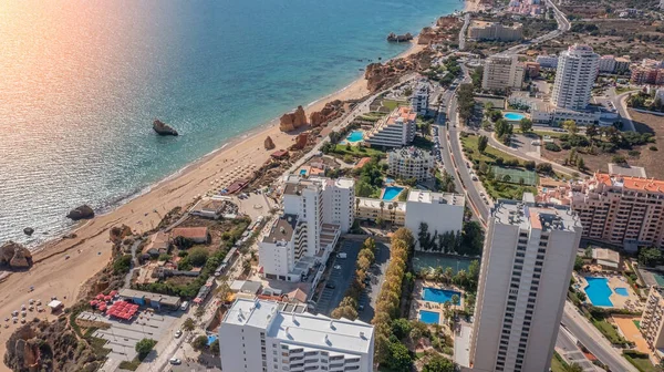 Vista aérea de la ciudad de Portimao sobre edificios residenciales, edificios de gran altura, en la playa Praia de Rocha con los turistas. Día soleado — Foto de Stock