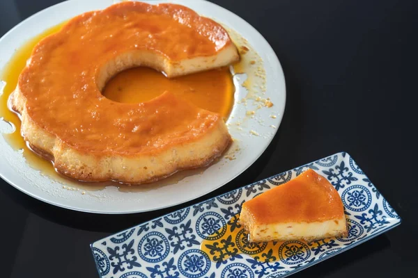 Pudding, heerlijk Braziliaans gecondenseerd melkdessert, in stukjes gesneden, op een bord. — Stockfoto