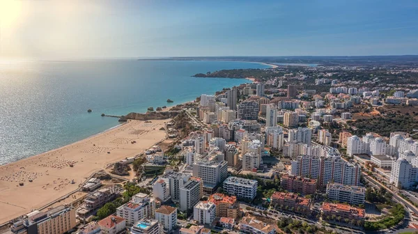 Veduta aerea della città di Portimao su edifici residenziali, grattacieli, sulla spiaggia Praia de Rocha con i turisti. Giornata di sole — Foto Stock