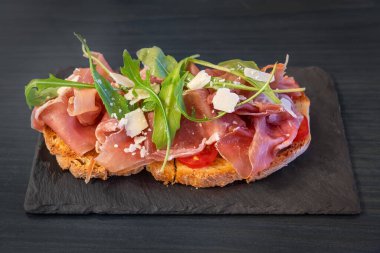 Jambonlu sandviç, peynir, domates ve salata. Taş tabakta. Kapat.