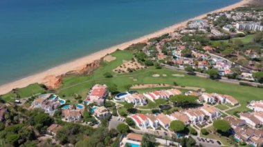 Vale de Lobo, Algarve, Portekiz, Avrupa 'daki Quinta do Lago tatil köylerinin hava manzarası. Yeşil manzaralı, arka planda dağlar olan lüks kulübelerin çatıları. Golf alanları.