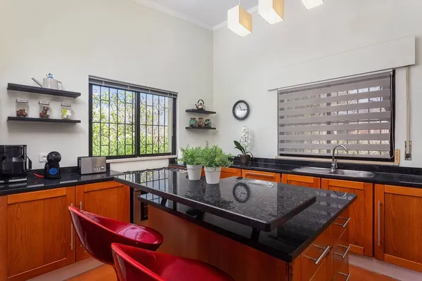 Cucina moderna e luminosa, con tavolo in marmo e piedistalli in legno. Per la preparazione e il consumo di cibo, per i residenti della casa. — Foto Stock