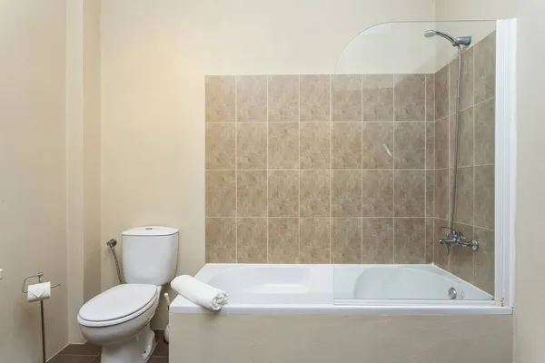 Modernes traditionelles Bad, mit Toilette, Badewanne, Keramikfliesen rundherum. Mit Trocknung, Handtuch, — Stockfoto