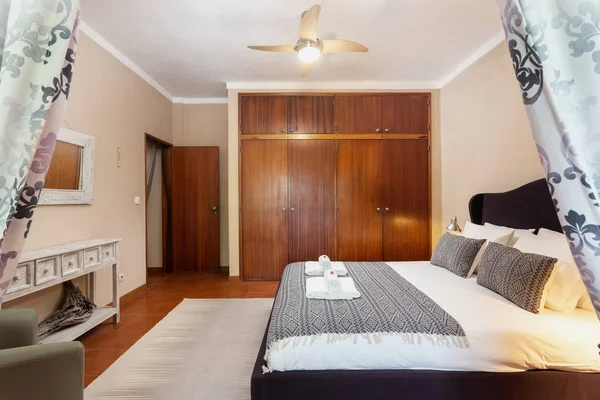 Quarto em estilo clássico mediterrânico tradicional com cama de casal. Com um espelho e toalhas com doces na cama. — Fotografia de Stock