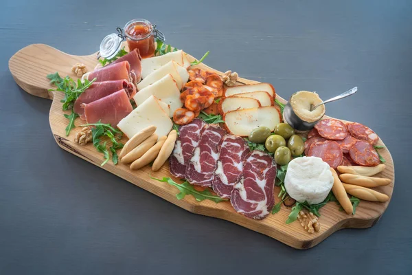 Very colorful tapas board of charcuterie with cheese and smoked meats. Decorated with arugula and walnuts. Wine snacks. — Stock Photo, Image