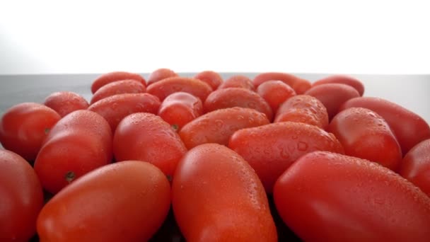 Mogna röda biologiska tomater på en slät glasyta. Går framåt, bakåt. Extremt makroekonomiskt. — Stockvideo