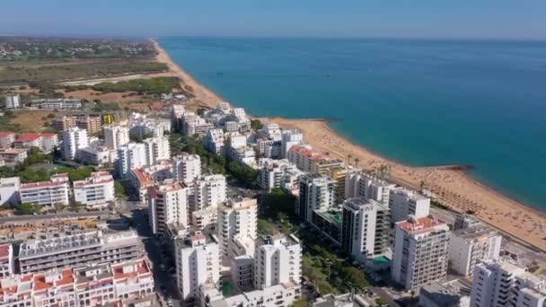 Imagens de drones, filmando a cidade turística de Quareira, nas margens do Oceano Atlântico, praias com turistas. Portugal, Algarve. — Vídeo de Stock