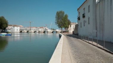 Antik Portekiz 'in tarihi kasabası Tavira, Arap köprüsü boyunca yürüyor, Gilao nehri üzerinde kaldırım taşları üzerinde. Dengeleyiciyle ateş etmek.