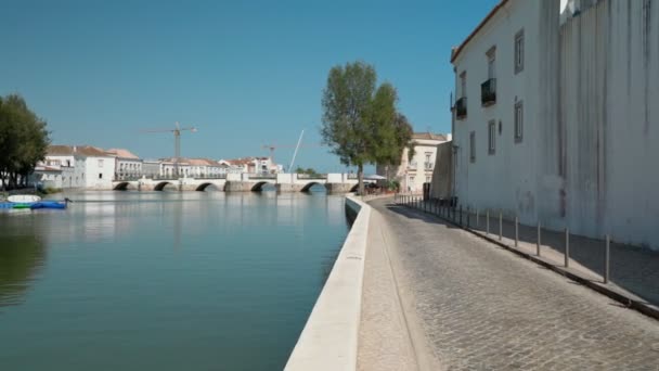 Antik Portekiz 'in tarihi kasabası Tavira, Arap köprüsü boyunca yürüyor, Gilao nehri üzerinde kaldırım taşları üzerinde. Dengeleyiciyle ateş etmek. — Stok video