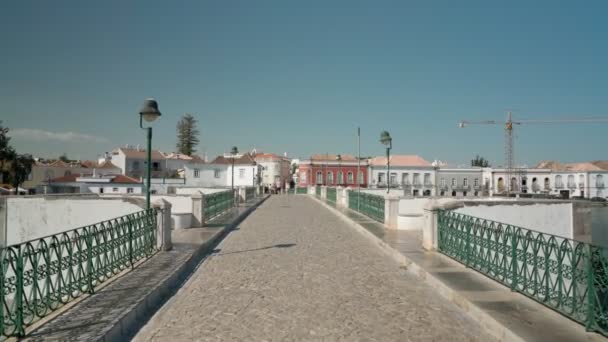 L'ancienne ville portugaise historique de Tavira, marche le long du pont arabe, sur la rivière Gilao sur les pavés. Tir avec un stabilisateur. — Video