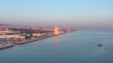 Portekiz Keşifler Anıtı 'na bakan muhteşem gün batımı manzarası Padrao dos Descobrimentos. Belem. Arka planda 25 Nisan köprüsü.