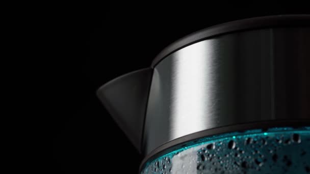 Acqua bollente per una bevanda, tè e caffè, in un bollitore elettrico di vetro, con luci blu. Primo piano. Su uno sfondo nero. — Video Stock