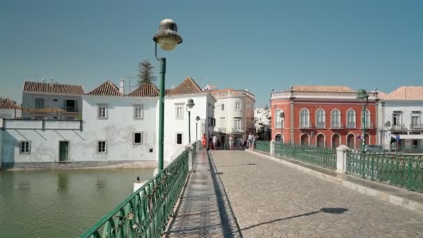 タビラの古代の歴史的なポルトガルの町は、石畳の上のギラオ川に、アラブの橋に沿って歩いています。安定剤で撃つ. — ストック動画