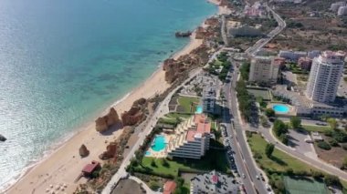 Portekiz 'in güneyindeki Portimao şehrinin çarpıcı plajları ve açık mavi denizin üzerindeki güzel hava manzarası. Şehir deniz manzarası.