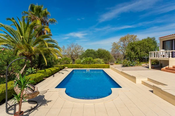 Modern villa medencével és trópusi kert pálmafákkal és hintaszékkel. A szálloda turisták szállója.. — Stock Fotó