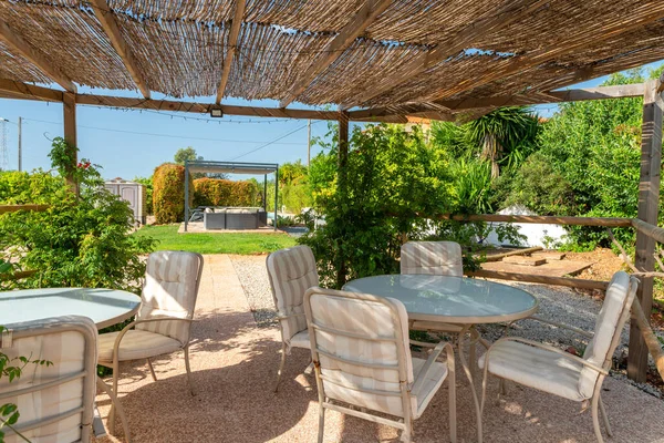 Внутренний вид на сад беседки в расслабляющей вилле отеля, гостиная со столом, стульями, травой и садом. Средиземноморский — стоковое фото