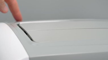 Taşınabilir mobil klima odanın ısıtılması, soğutulması veya nemden arındırılması için açılır. Yakın plan. Başlat düğmesi, parmak.