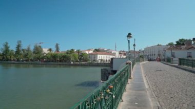 Antik Portekiz 'in tarihi kasabası Tavira, Arap köprüsü boyunca yürüyor, Gilao nehri üzerinde kaldırım taşları üzerinde. Dengeleyiciyle ateş etmek.