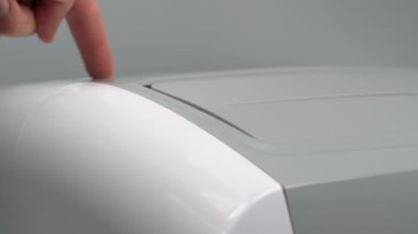 Taşınabilir mobil klima odanın ısıtılması, soğutulması veya nemden arındırılması için açılır. Yakın plan. Başlat düğmesi, parmak.