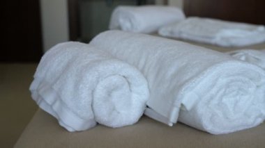 Yatak ve yastıklı modern otel odası videosu. Ve pansiyon ziyaretçileri için beyaz havlular ve bornoz. Yakın çekim..