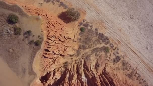 Images aériennes de la descente en douceur de falaises sablonneuses et de collines érodées sur la plage portugaise de Falesia. — Video