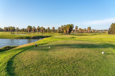 Temiz göletleri ve rahatlama ve golf için palmiye ağaçları olan turistler için modern golf sahaları. Albufeira, Algarve