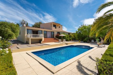 Havuzu, tropik bahçesi, palmiye ağaçları ve sallanan sandalyesi olan modern bir villa. Otel turistler için bir pansiyondur..