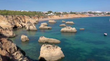 Portimao şehrinin yakınlarındaki Portekiz kayalık plajlarının hoş hava manzarası. Turistlerin geri kalanı için. Algarve.