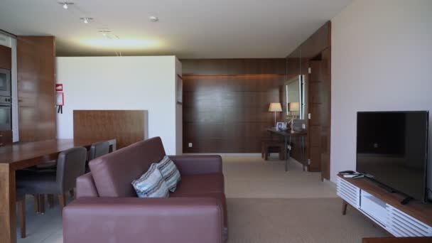 木制的现代客厅，有一张皮革沙发桌子和一个大的长椅，电视. — 图库视频影像