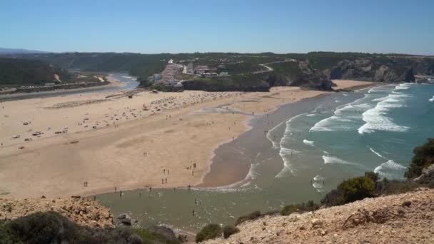 Filming the beautiful bay in the Portuguese town of Odeceixe in the summer with tourists on the beach. — 图库视频影像