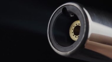 Gaz ocağından düşük alev, endüstrideki bir ısıtma ve ateşleme aracı. Siyah bir arkaplanda yakın plan