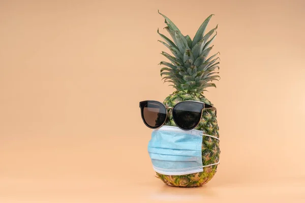 Interprétation de l'ananas sous forme humaine lors d'une pandémie portant des lunettes de soleil et un masque protecteur pour les médecins. Espace de copie sur fond jaune — Photo