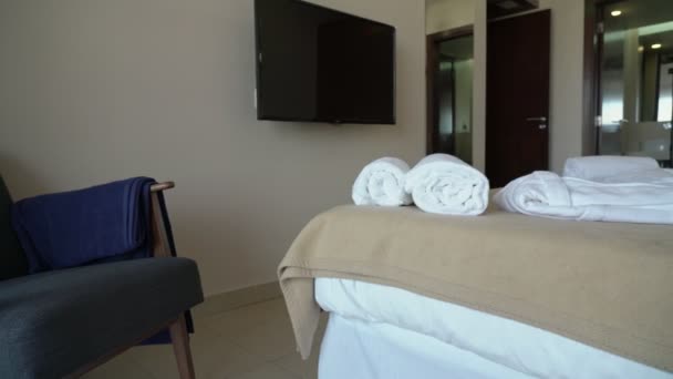 Yatak ve yastıklı modern otel odası videosu. Ve pansiyon ziyaretçileri için beyaz havlular ve bornoz.. — Stok video