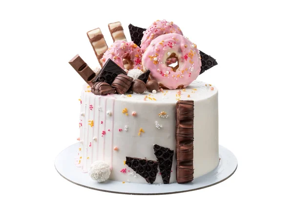 Colorfully decorated chocolate white cake with sweets and donuts. Close up on white background — ストック写真