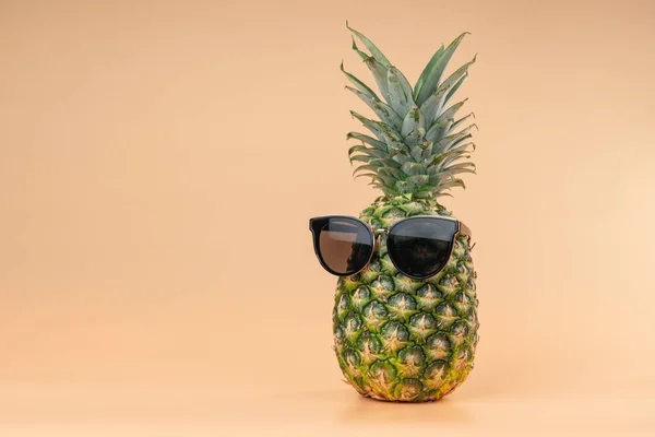 Interpretation of pineapple fruit in the human image in the sun goggles tourism and vacations concept. Copy space on yellow background — Fotografia de Stock