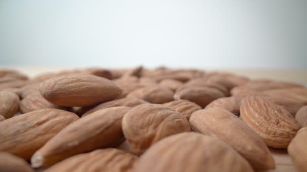 Lento movimento cair e amêndoas na mesa de close-up. Alimentação e dieta saudáveis. — Vídeo de Stock