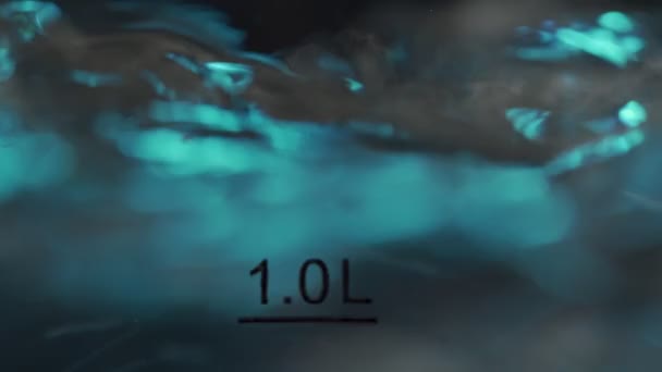 Burbujas borrosas en agua caliente hirviendo dentro de una tetera de vidrio bajo luz azul. Primer plano en macro cámara lenta — Vídeos de Stock
