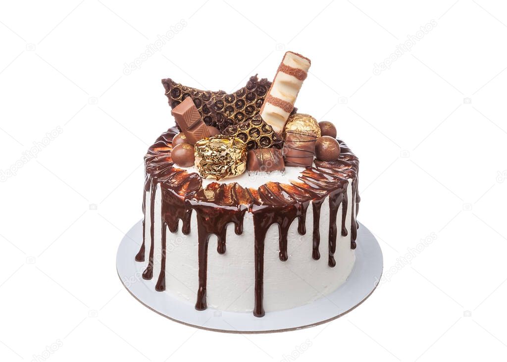 Colorfully decorated chocolate white cake with sweets and donuts. Close up on white background