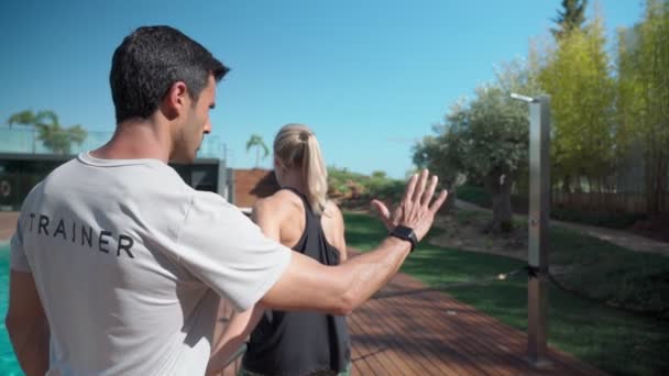 Junge athletische Fitness-Frau und Personal Trainerin bei Übungen zur Wiederherstellung und Stärkung der Schulter nach einer Verletzung. Im Park draußen. — Stockvideo