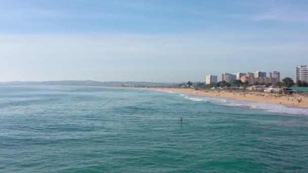 Aerial view of beautiful Portuguese beaches with tourists surfers boarding in the Algarve in the south. Paddleboard — Stock Video