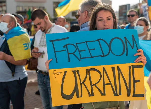 FARO-PORTUGAL - 2022年2月27日：反战抗议或反对入侵乌克兰的集会。拿着硬纸板横幅和纸板、旗帜的示威者。自由乌克兰 — 图库照片