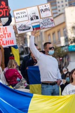 FARO-PORTUGAL - 27 Şubat 2022 Ukrayna 'nın işgaline karşı savaş karşıtı protestolar veya mitingler. Karton pankartlı, pankartlı, bayraklı göstericiler. Öldürücü. Putin.