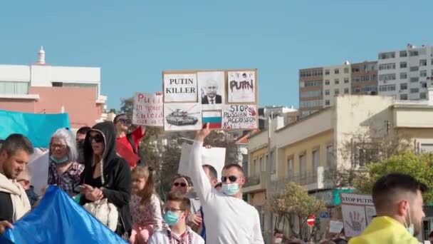 FARO-PORTUGAL - 27. Februar 2022: Antikriegsprotest oder Kundgebung gegen die Invasion der Ukraine. Demonstranten mit Pappbannern und -tafeln, Fahnen. Kein Krieg. — Stockvideo